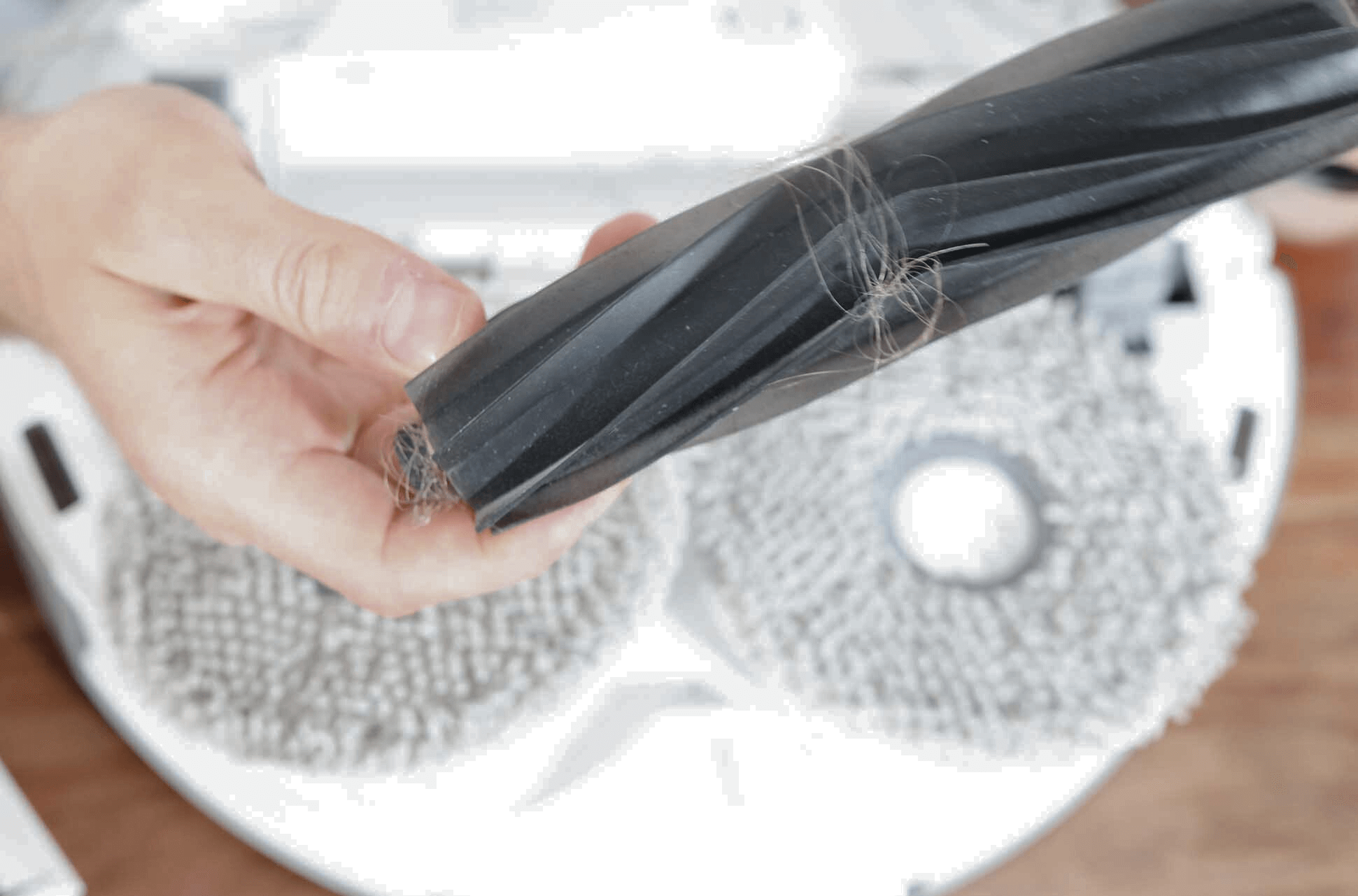 Die Gummibürste des ECOVACS DEEBOT T20 OMNI wird in den Händen gehalten.